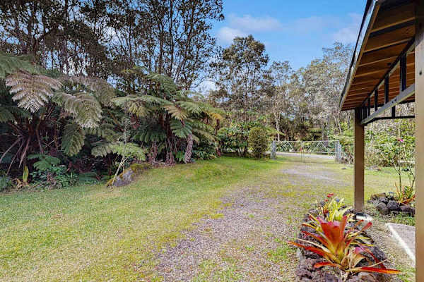 View Looking Toward Entry Gate Along Gravel Path and Lush Tropical Garden