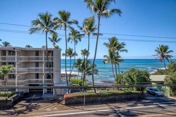 Beautiful resort building exterior featuring tropical palm trees and stunning ocean views! 🌴🌊😎