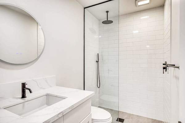Pristine Modern Bathroom Featuring A Custom Subway Tile Shower