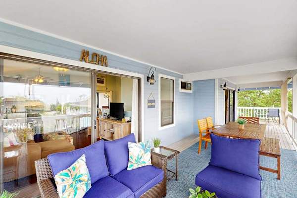 Beautiful covered balcony lounge featuring plush blue seating, tropical accent pillows, and a spacious layout for outdoor relaxation! 🛋️☀️