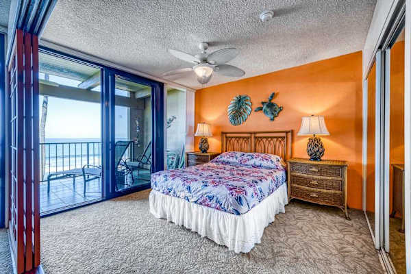 Bright bedroom featuring a comfortable bed, accent wall, and sliding doors to a private balcony!