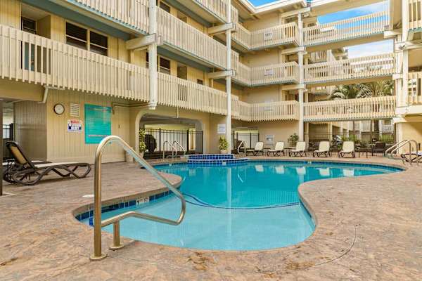 Sparkling community outdoor swimming pool with comfortable poolside lounge chairs