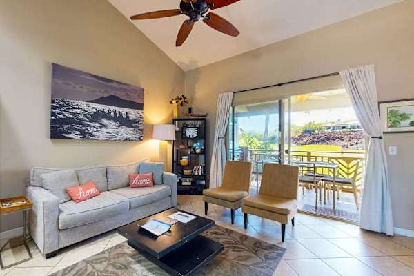 Living room with vaulted ceilings and large screen door for fresh air and natural light.