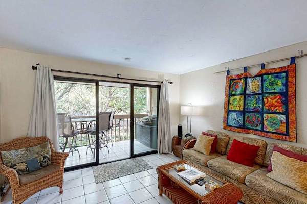 Open living room that opens up to a private outdoor balcony through large sliding glass doors