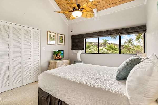 A comfortable bedroom layout featuring a large closet, dresser storage, and scenic window views