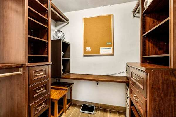 An expansive walk-in closet featuring extensive built-in shelving, drawers, and hanging space