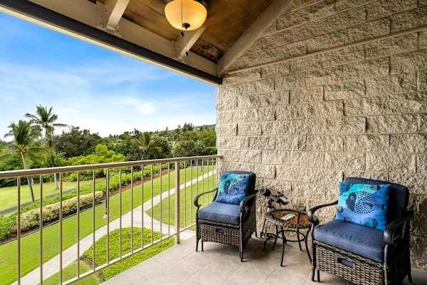 Unwind on the balcony featuring comfortable armchairs and sweeping tropical views