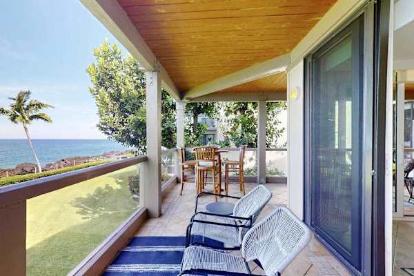 Covered Oceanfront Balcony with Outdoor Lounge Chairs, Dining Table, and Ocean Views