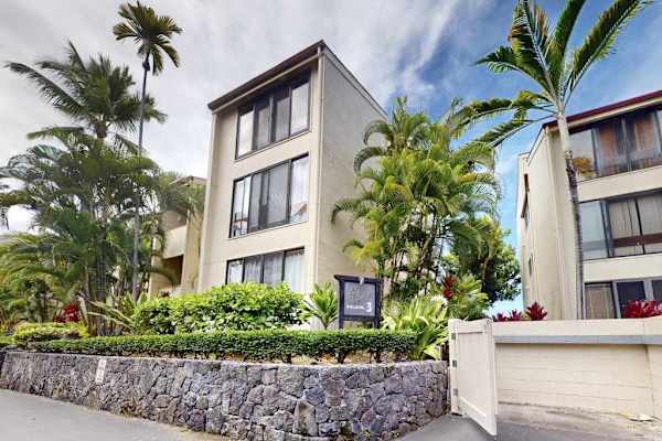 Modern Multi-Story Resort Building Exterior Framed by Tropical Palm Trees and Landscaping