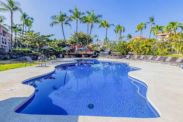 Crystal-Clear Resort Swimming Pool Surrounded by Sun Loungers & Palms