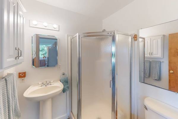 Bright Guest Bathroom featuring Pedestal Sink & Walk-In Glass Shower