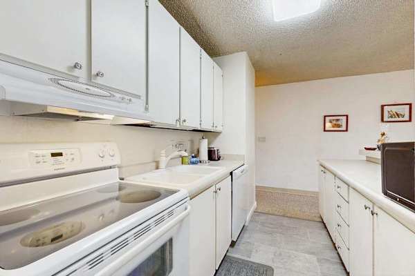 Kitchen Setup with Electric Range, Oven & White Cabinetry
