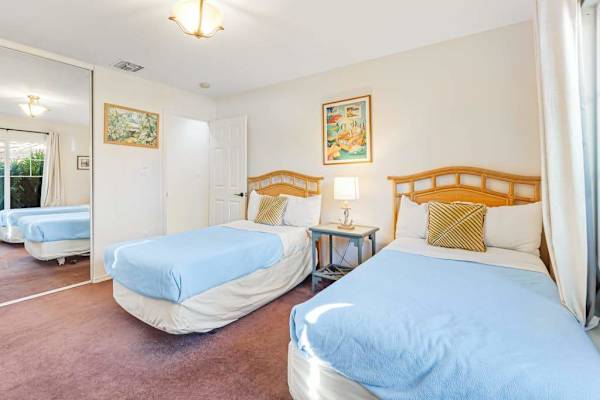 Guest room with two single beds and a flat screen tv.