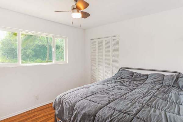Master bedroom with queen bed and lots of light from the windows.