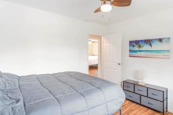 Master bedroom with queen bed and lots of light from the windows.