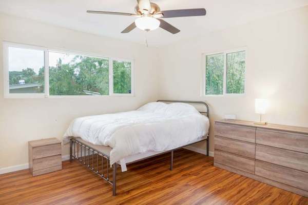 Guest room with double bed and a ceiling fan.