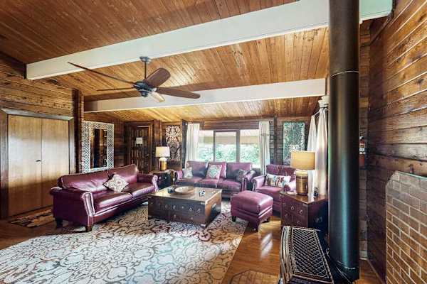 This home has an open-concept indoor living design with modern furnishings, vaulted ceilings, and even a gas fireplace for warming up on those high-elevation cool and damp volcano evenings