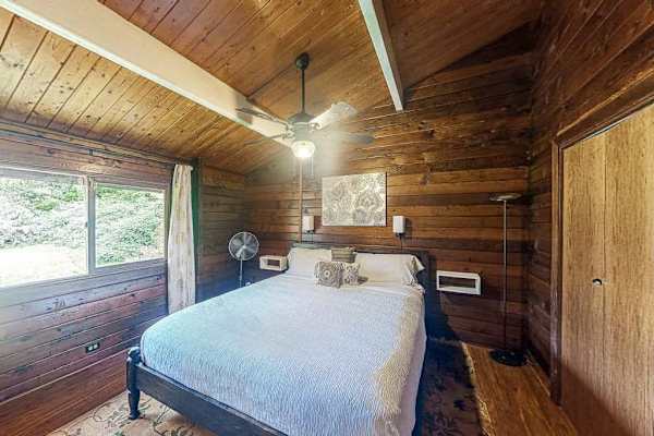 Guest bedroom with a queen bed, ceiling fan and lots of natural light. 