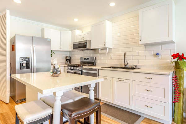 Fully Equipped Modern Kitchen with Island Stools and Stainless Steel Appliances