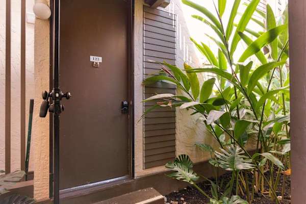 Private Front Entrance Door with Unit Signage & Tropical Greenery