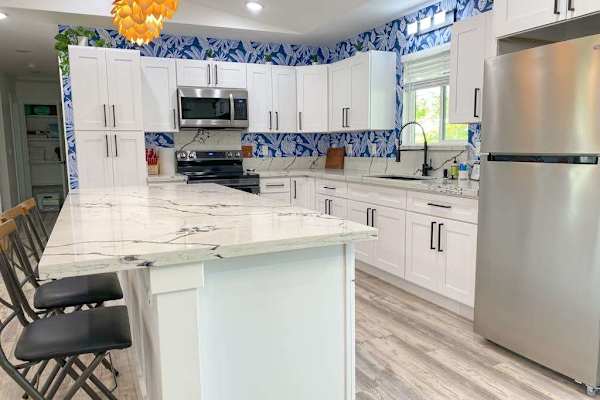 Well-equipped, island kitchen complete with black stainless steel appliances, gorgeous quartz countertops, and counter seating. Prepare your favorite recipes in this spectacular space and then dine together at the adjacent table.