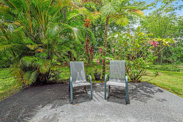 Escape to a private tropical backyard oasis surrounded by lush Hawaiian landscaping, swaying palms, and the peaceful beauty of paradise.