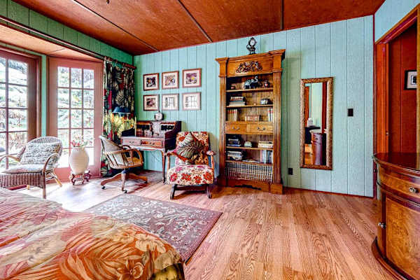 Guest room with a queen bed and large picture windows.