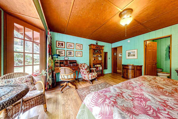 Guest room with a queen bed and large picture windows.