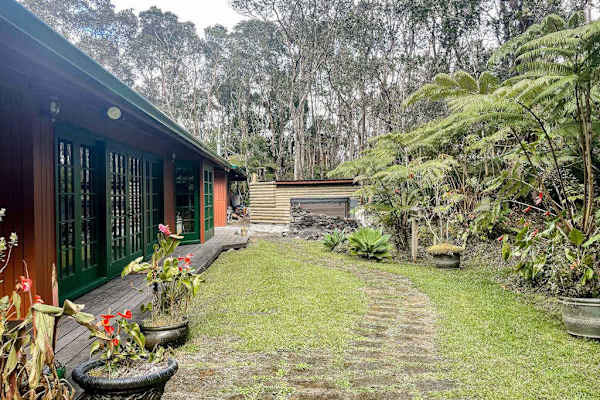 Escape to a private tropical backyard oasis surrounded by lush Hawaiian landscaping, swaying palms, and the peaceful beauty of paradise.