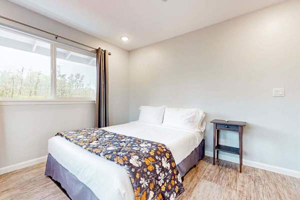 Guest room with queen bed and large picture windows. 