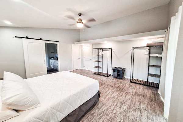 Large master bedroom with king bed and sliders to access the outside.