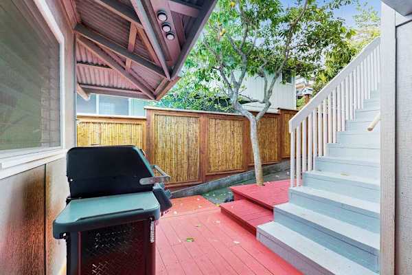 Outdoor BBQ area provides grill space beside steps and greenery