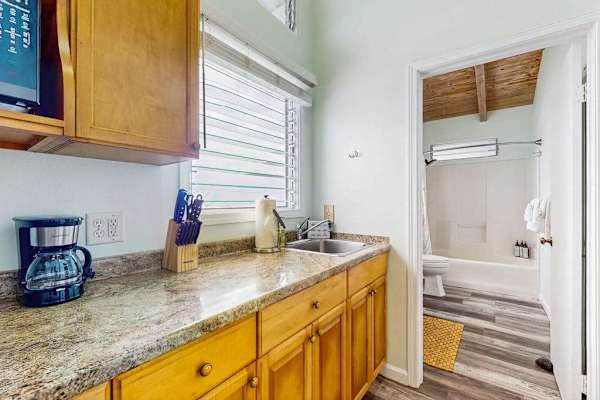 Bathroom vanity includes mirror storage and bright natural lighting nearby