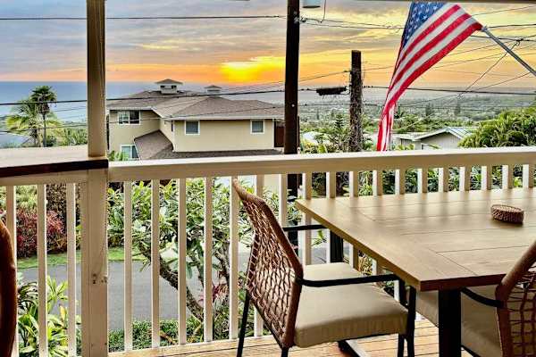 Balcony table seating overlooks nearby homes gardens and island scenery