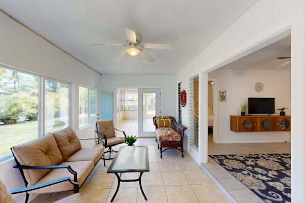 Open living room offers seating television ceiling fan and views