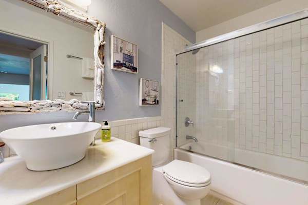 Full bathroom features vanity shower toilet and bright natural lighting