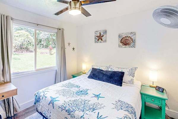 Guest room with queen bed, ceiling fan and extra fan for your comfort.