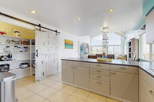 Large open update kitchen with stainless steel appliances.