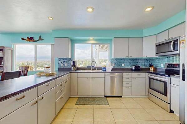 Large open update kitchen with stainless steel appliances.