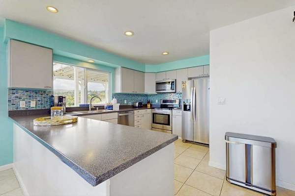 Large open update kitchen with stainless steel appliances.