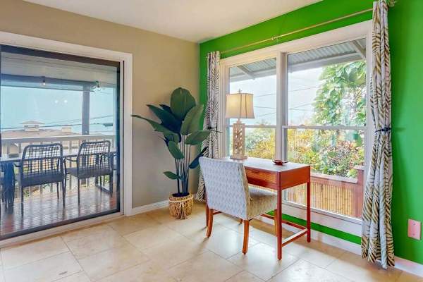 Dining nook pairs a round table with windows and greenery