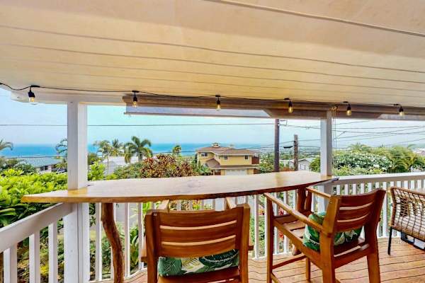 Open lanai provides relaxed seating above tropical gardens and coastline