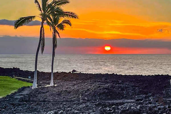 Experience Hawaii's picturesque sunsets as vibrant shades of orange, pink, and blue paint the sky above the Pacific Ocean.