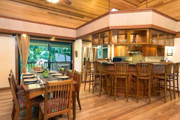 Kitchen and dining area combine wood cabinetry with garden views