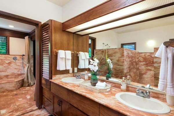 Stone bathroom showcases a soaking tub, marble walls, and fixtures