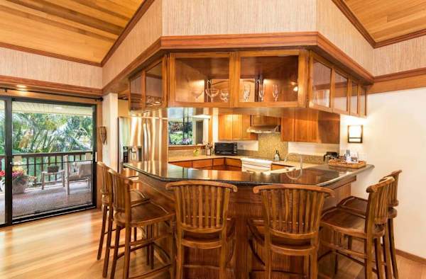 Kitchen features a breakfast bar, wooden cabinetry, and organized appliances
