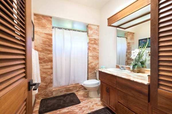 Contemporary bathroom showcases a shower, vanity, and warm tilework