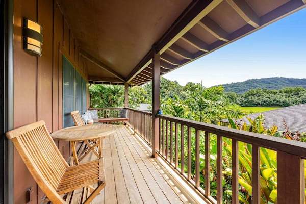 Covered balcony features rocking chairs, scenic hills, and fresh breezes