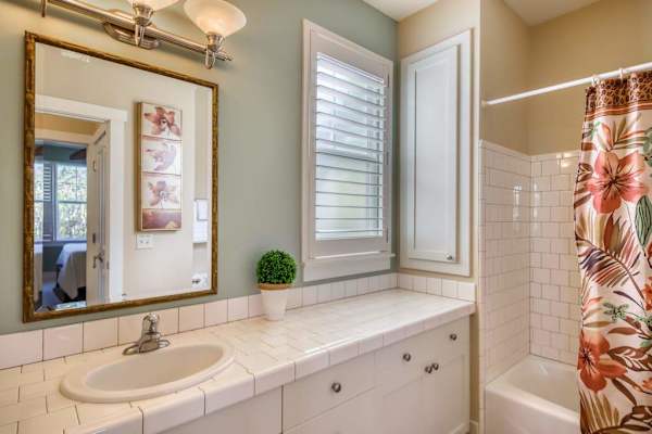 Bright Guest Bathroom with Large Mirror & Floral Shower Curtain