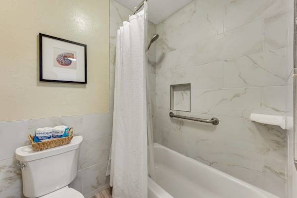 Bathroom Tiled Combination Bathtub and Shower with Grab Bar and Toilet